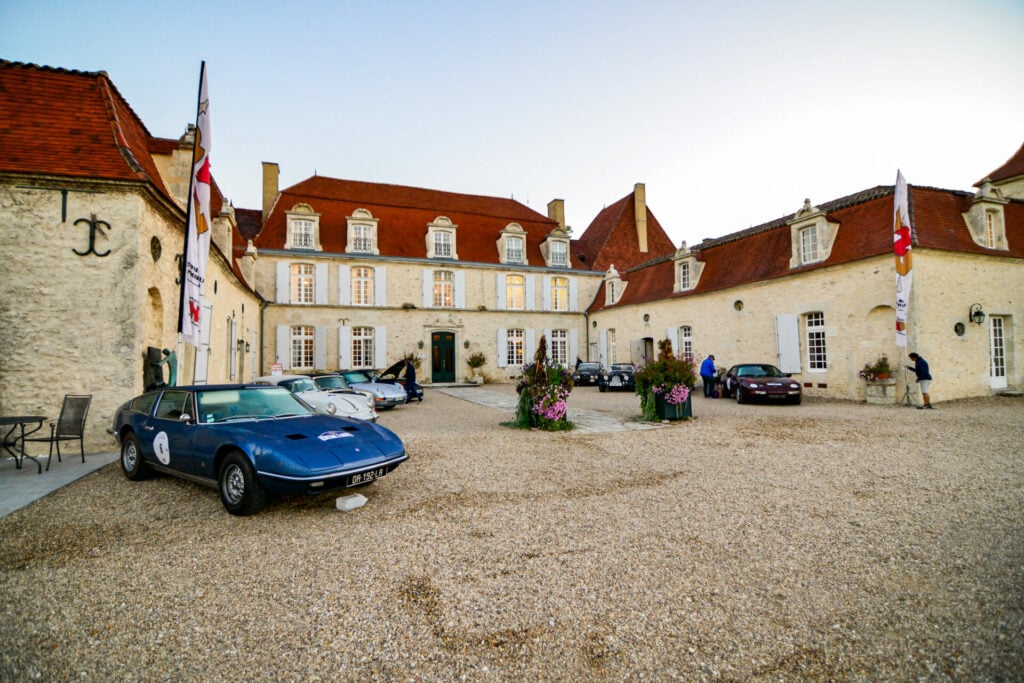 Deux voitures de course dans la cour d’une demeure de prestige
